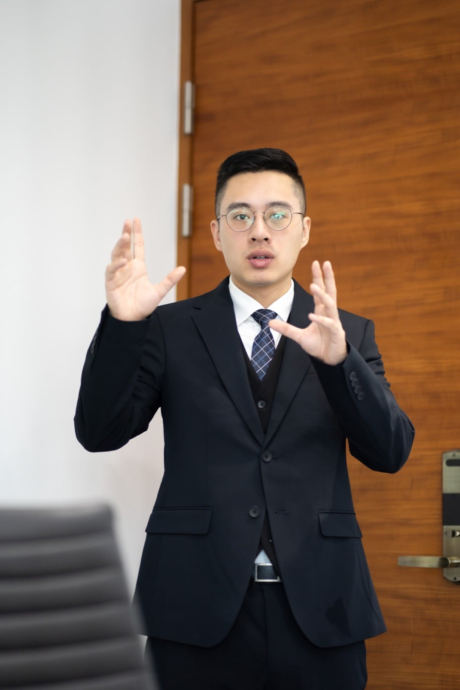 張哲豪律師於室內說明與討論的工作情境照